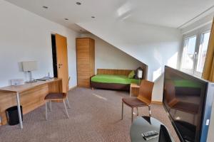 a hotel room with a bed and a tv at Hotel Hecht Garni in Ingolstadt