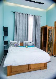 a bedroom with a large bed with a window at RJ's Apartments Korogwe in Korogwe