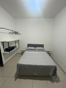 a bedroom with a bed in a white room at Casa de praia in Marechal Deodoro