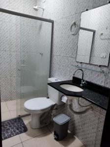 a bathroom with a toilet and a sink and a shower at Casa de praia in Marechal Deodoro
