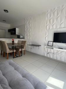 a living room with a table and a tv at Casa de praia in Marechal Deodoro