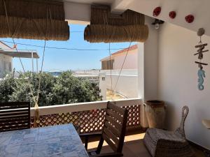 a balcony with a table and chairs and a view of the ocean at El Chalet in Punta Umbría