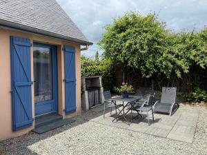 a patio with a table and chairs next to a house at Suite à 800m de la plage in Saint-Lunaire