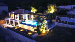 an aerial view of a house with a swimming pool at night at Carmelia Villas in Agios Nikitas