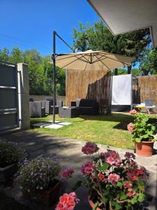 a patio with an umbrella and some flowers at Relax da Sabry in Senigallia