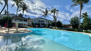 a large swimming pool with palm trees in the background at Mtwapa Beach Nest D3 in Mtwapa
