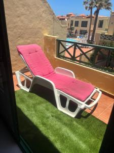 a pair of pink chaise lounge chairs on a balcony at Mi Amor in Caleta De Fuste