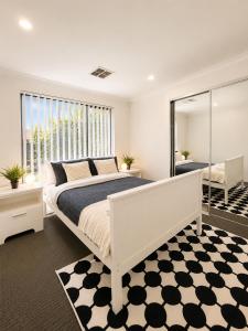 a bedroom with a white bed and a large window at Modern oasis in Perth