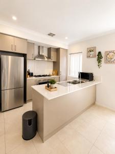 a kitchen with a sink and a refrigerator at Modern oasis in Perth +2 photos