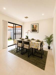a dining room with a table and chairs at Modern oasis in Perth