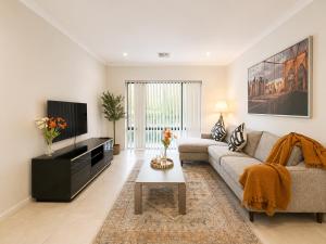 a living room with a couch and a tv at Modern oasis in Perth