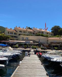 a dock with boats in the water next to a building at Azurea in Saint-Cyr-sur-Mer