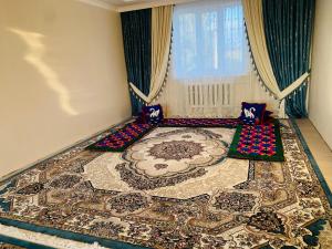 a room with a large rug on the floor at Khan Dobo in Bokonbayevo