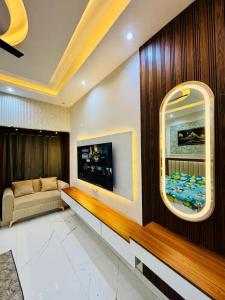 a living room with a couch and a tv on a wall at THE MOONLIGHT STUDIo in Ghaziabad