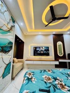 a living room with a ceiling fan and a tv at THE MOONLIGHT STUDIo in Ghaziabad +6 photos
