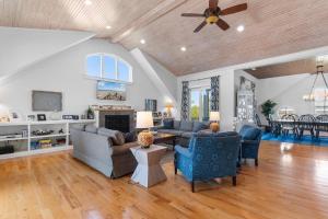 a living room with couches and a ceiling fan at Elegant Beachfront Escape with Wrap-Around Porches in Pawleys Island