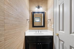 a bathroom with a sink and a mirror at Elegant Beachfront Escape with Wrap-Around Porches in Pawleys Island +42 photos