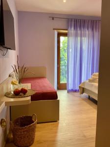 ein Schlafzimmer mit einem Bett und einem Fenster mit lila Vorhängen in der Unterkunft Borgo Poli in Fanano