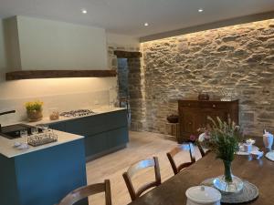 eine Küche und ein Esszimmer mit Tisch und Theke in der Unterkunft Borgo Poli in Fanano + 22 Fotos