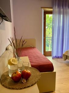 ein Zimmer mit einem Bett und zwei Äpfeln auf einem Tisch in der Unterkunft Borgo Poli in Fanano