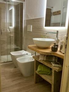 ein Badezimmer mit Waschbecken, Toilette und Badewanne in der Unterkunft Borgo Poli in Fanano