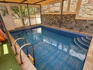 a lap pool in a house with windows and a swimming pool at Casa Rural El Castillo in Málaga