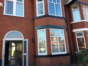 un edificio de ladrillo rojo con ventanas blancas y una puerta en Park Drive TownHouse, en Mánchester