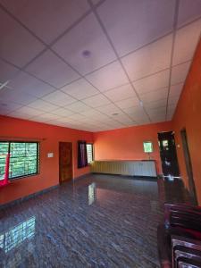 an empty room with orange walls and a room with a unintention at Kaarmugilu Homestay in Kalasa