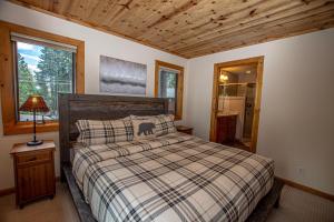 a bedroom with a bed with a plaid blanket at Bonanza By Hauserman Rentals in Tahoe City