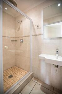 a bathroom with a shower and a sink at Luxury Suites on Santorini in East London +58 photos