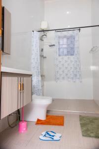 a bathroom with a toilet and a shower and a rug at RJ's Apartments Korogwe in Korogwe +53 photos