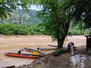 a group of people standing next to boats on a river at Brisas de la Bujona in Honda
