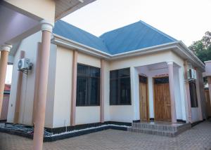 a small white house with a blue roof at RJ's Apartments Korogwe in Korogwe