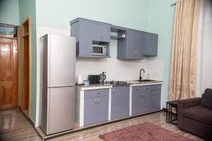 a kitchen with a white refrigerator and a microwave at RJ's Apartments Korogwe in Korogwe