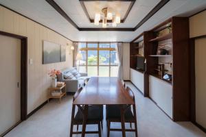 a dining room with a table and a couch at Tiger House Kusabana in Akiruno
