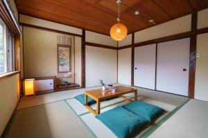a living room with a table and a couch at Tiger House Kusabana in Akiruno