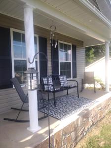 a porch with two chairs and a bench on a house at Lil ranch in White Pine +7 photos