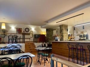 a restaurant with tables and chairs and a bar at Aparthotel les Corts in Llivia