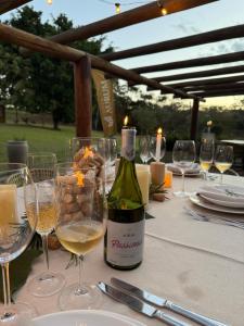 a bottle of wine sitting on a table with glasses at Vinícola Villa Aurum in Corumbá de Goiás