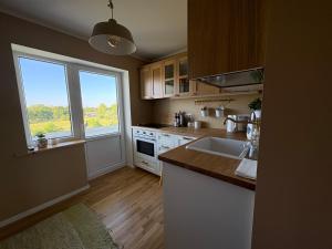 a kitchen with a sink and a large window at Mõnus peatuspaik Saaremaa põhjaranniku avastamiseks in Myustelʼ