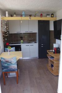 a kitchen with white cabinets and a table and a counter at One Bedroom Apartment in Banjol