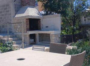 ein Außenofen mit Tisch und Stühlen in der Unterkunft Apartman Intrada in Neum