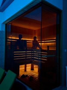 a man and a woman sitting on a bench at Laguna Boutique Hotel Bazaleti Lake in Dushetʼi