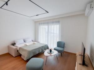 a bedroom with a bed and two chairs and a tv at Azzurro Vista in Budva