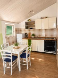 a kitchen with a white table and chairs at Apartments Marko in Vodice