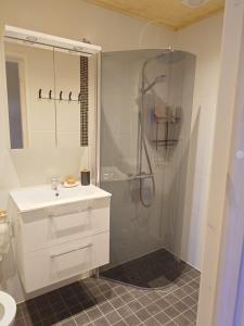 a white bathroom with a shower and a sink at Mõnus peatuspaik Saaremaa põhjaranniku avastamiseks in Myustelʼ
