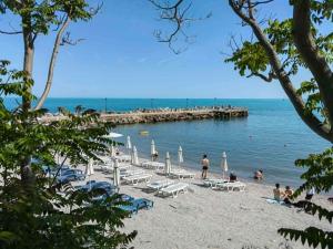 a beach with chairs and people in the water at Vanito Art Escape in Nesebar
