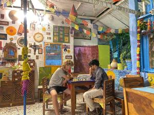 two people sitting at a table playing a board game at Bob hostel in Jodhpur