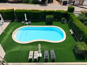 eine Draufsicht auf einen Swimmingpool mit Liegestühlen und einer Liegewiese in der Unterkunft Hotel Ignacio - PalomarGroup in Chiva