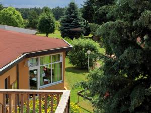 a house with a balcony and a yard with trees at Holländer Mühle Rheinsberg in Rheinsberg